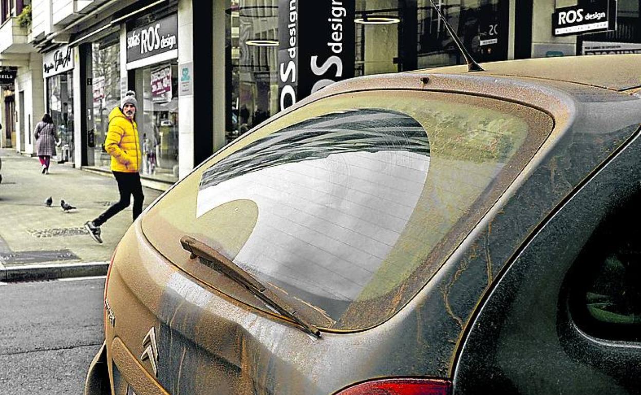 Un coche cubierto por la calima en una calle de Vitoria. 