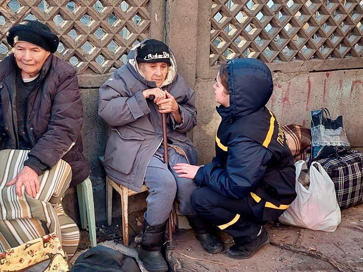 Un miembro del servicio de rescate consuela a una persona después de que un edificio residencial fuera alcanzado por un bombardeo.
