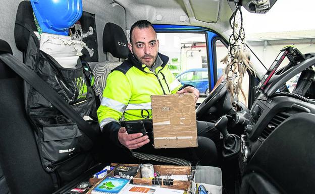 Iker Cano ordena sus útiles de trabajo en la furgoneta de reparto, en Galdakao. 