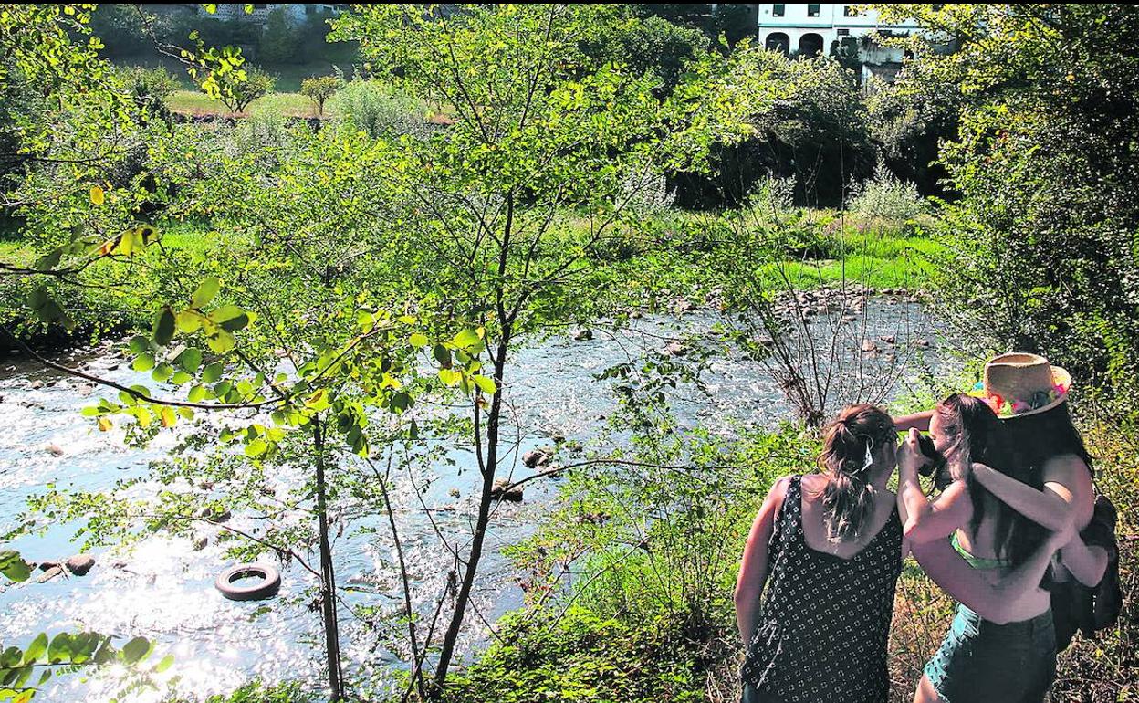 Jóvenes contemplan la suciedad del río Nervión a su paso por Arrankudiaga. 