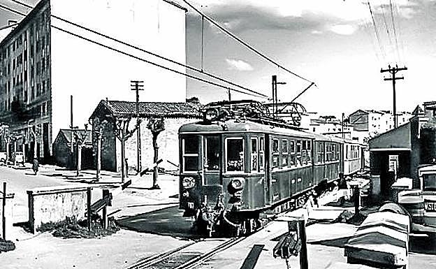 Paso a nivel de la calle Olaguíbel. Barreras bajadas al paso de un convoy del Vasco Navarro en el cruce de la calle Olaguíbel con la actual José Mardones. 