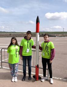 Imagen secundaria 2 - Los dispositivos, antes de ser lanzados, preparados con su paracaídas, y varios alumnos de Madre de Dios Ikastetxea con uno de los cohetes en los que fueron introducidos. 