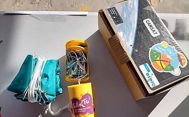 Imagen principal - Los dispositivos, antes de ser lanzados, preparados con su paracaídas, y varios alumnos de Madre de Dios Ikastetxea con uno de los cohetes en los que fueron introducidos. 