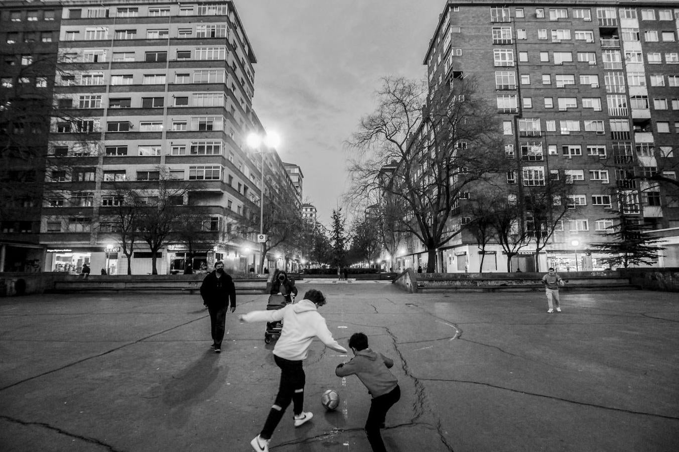 Varios chavales se divierten con el balón al caer la noche en la pista de cemento situada en Alfonso XI.