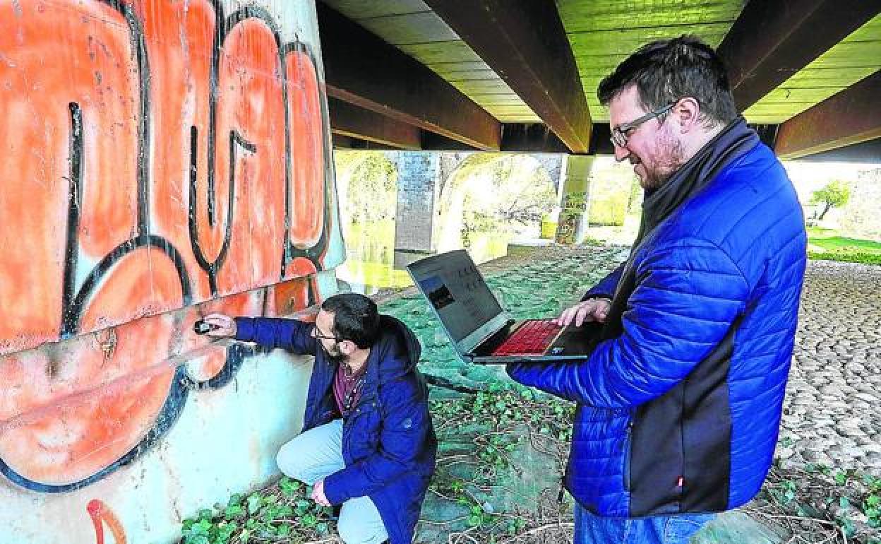 Dos trabajadores de Inalia, instalan uno de sus dispositivos en el puente de Abetxuko. 
