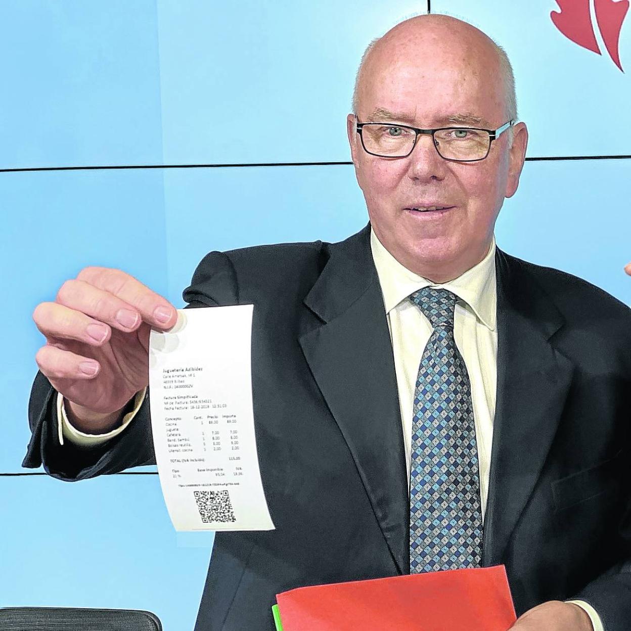 El diputado de Hacienda de Bizkaia, José María Iruarrizaga, muestra un ticket con el código informático. 