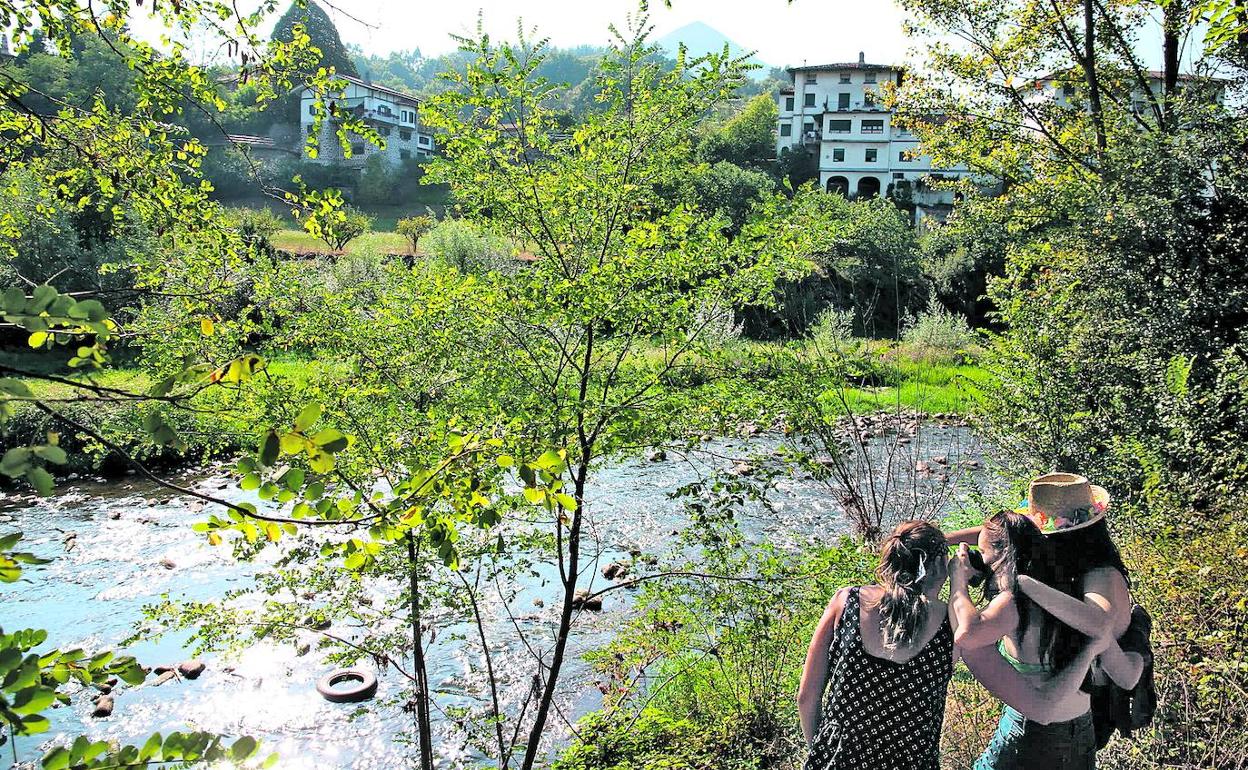 Jóvenes observan la suciedad del Nervión a su paso por Arrankudiaga. 