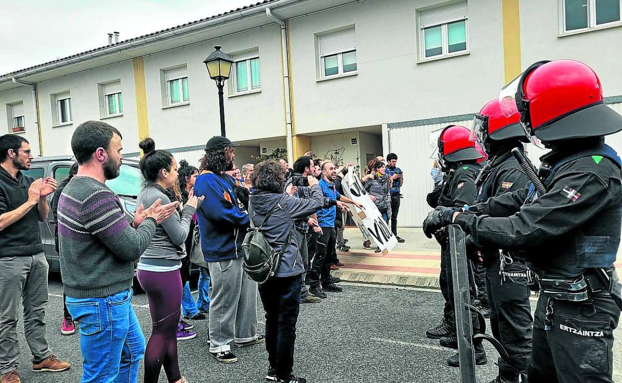 Vecinos aplauden a Itziar Baliñas al abandonar la casa por orden judicial frente al cordón de la Ertzaintza. 