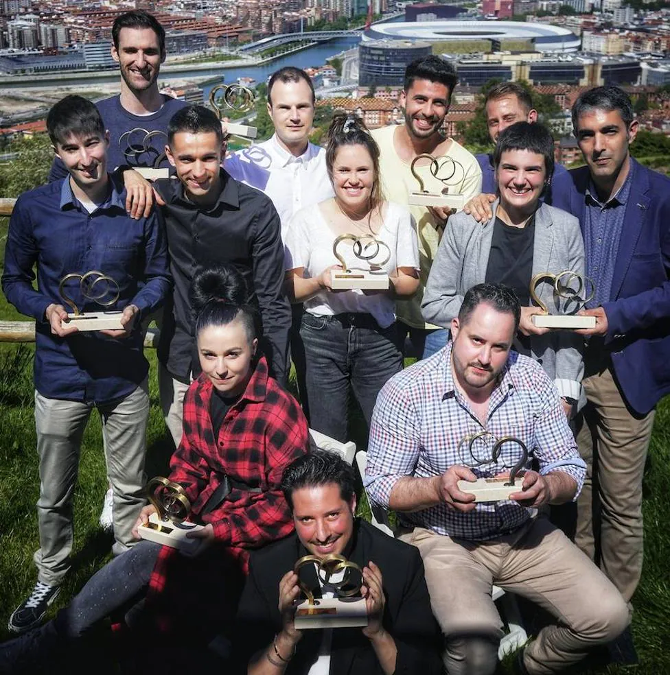 Los doce profesionales galardonados con los premios Talento Gastro de EL CORREO posan con sus trofeos en la terraza de Etxekobe, con Bilbao a sus espaldas. 