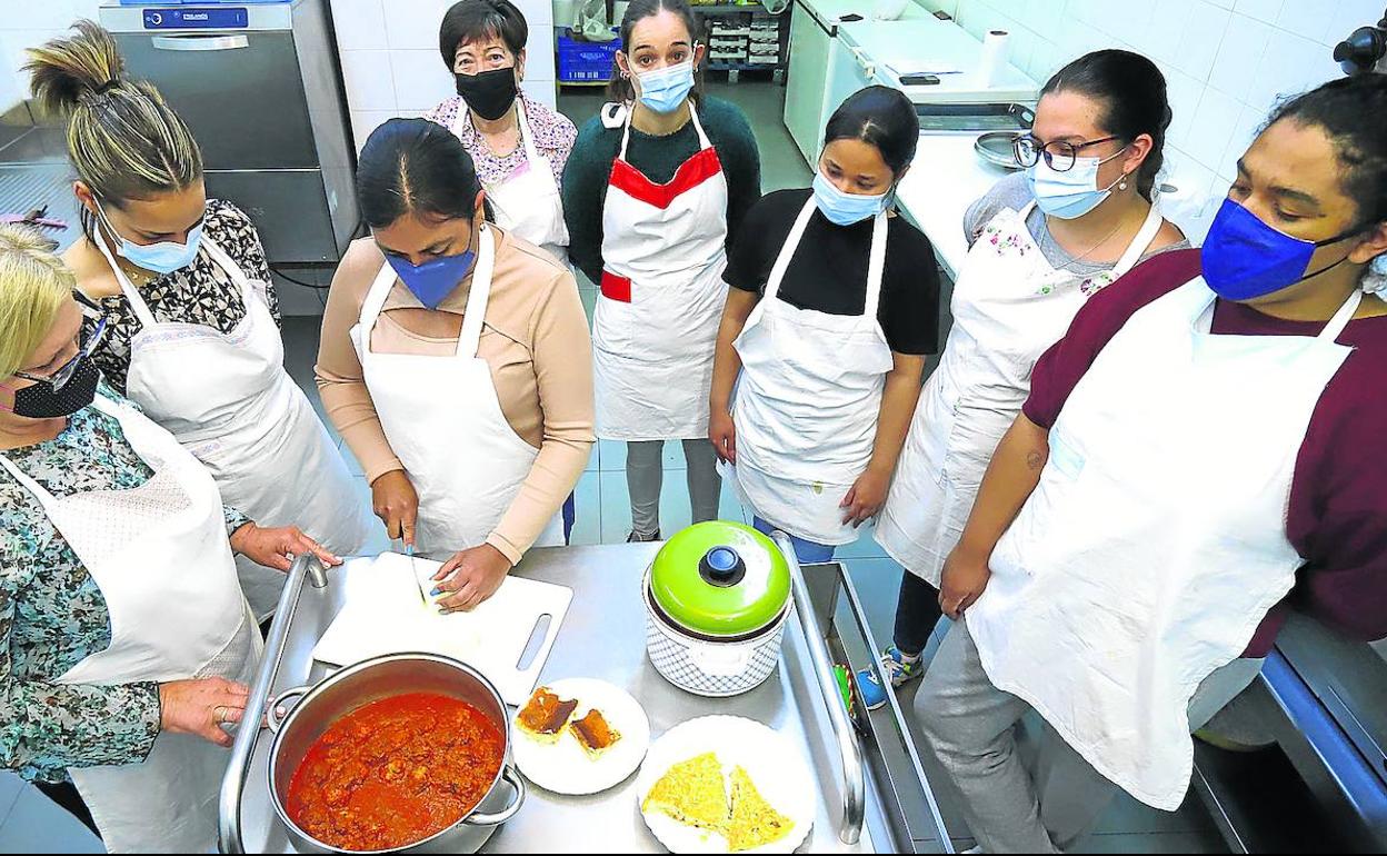 Voluntarias de Cáritas se encargan de las clases de cocinas en el curso de servicio doméstico y atención a dependientes.