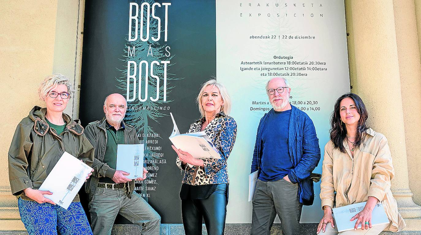 Den XL, Víctor Arrizabalaga, Maite Sainz Aldecoa, Iñigo Arregi y Nerea Moreno, ante el cartel de la muestra, con los catálogos.