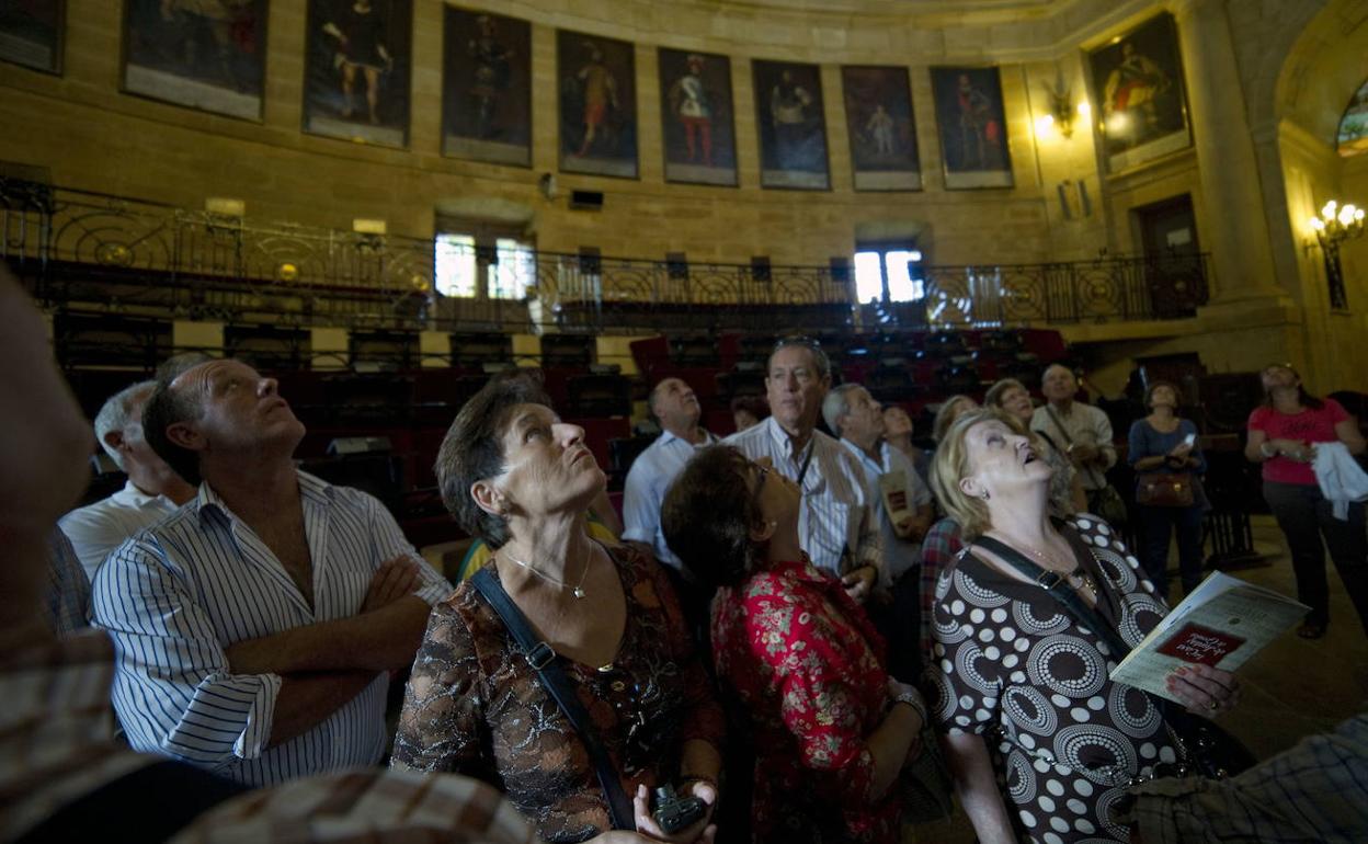 Visitantes de la Casa de Juntas de Gernika observan el techo del salón de plenos. 