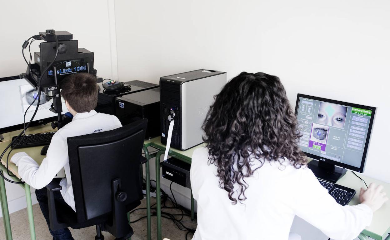 Un alumno del centro vitoriano y una investigadora durante uno de los estudios en el laboratorio. 