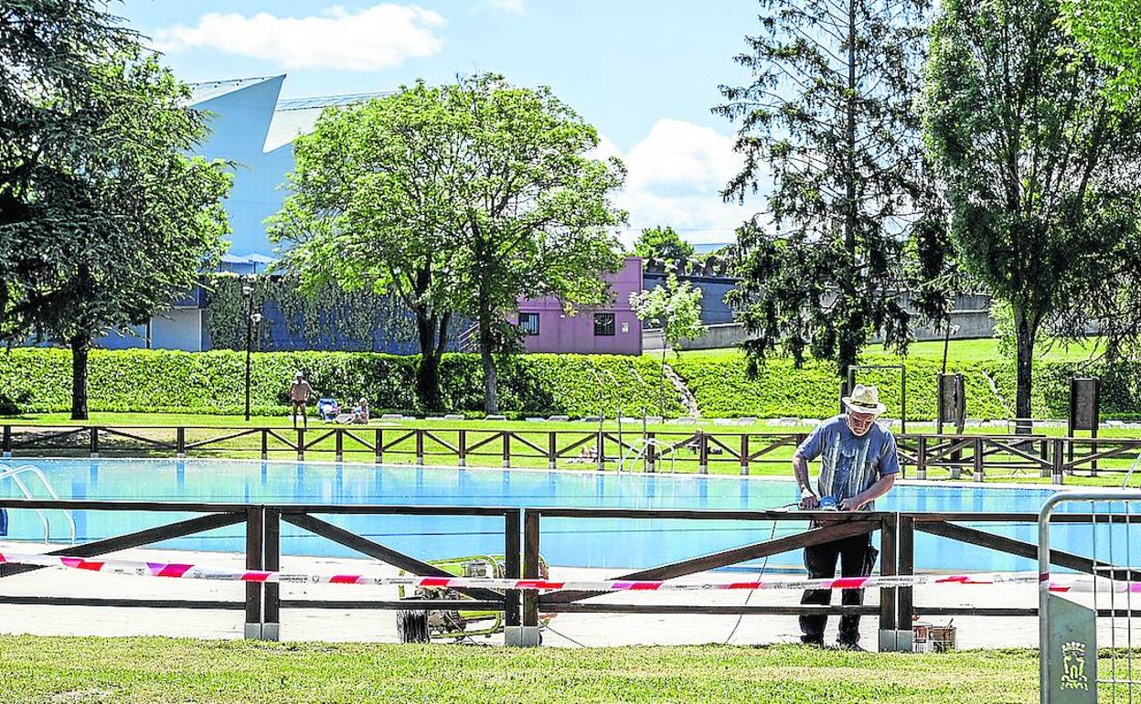 Un operario da los últimos retoques al vallado que separa una de las piletas de la zona verde. 