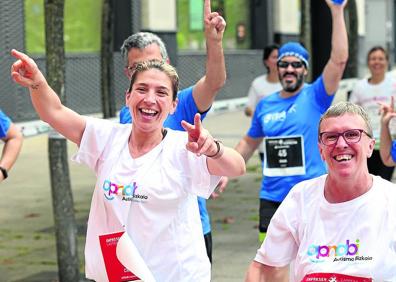 Imagen secundaria 1 - Txus Diharce recibe el cheque solidario de Patricia Arias. El buen humor no faltó en la prueba pese a que había que afrontar una carrera de ocho kilómetros. Numerosas personas, entre ellas familiares de los corredores, animaron a lo largo de todo el recorrido.