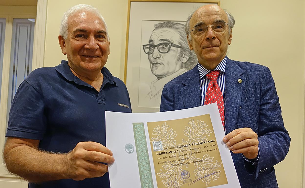 Iurretako idazleak Bilboko Euskaltzaindiaren egoitzan jaso du aitortza Andres Urrutia euskaltzainburuaren eskutik. 