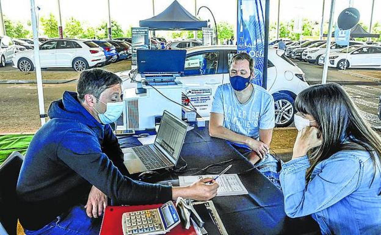 Clientes se interesan por un coche en la feria del año pasado. 