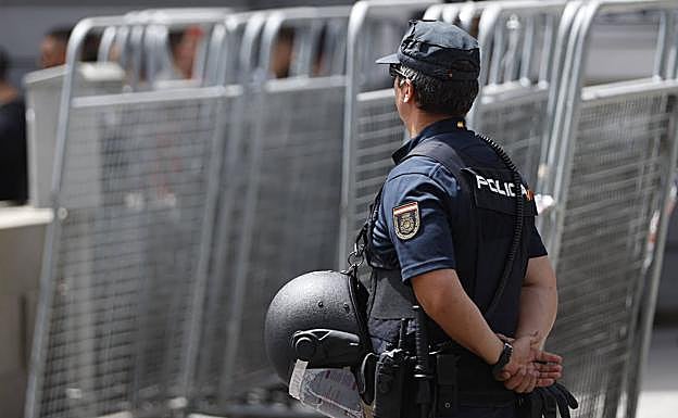 Un policía vigila junto a varias vallas de seguridad en Madrid.