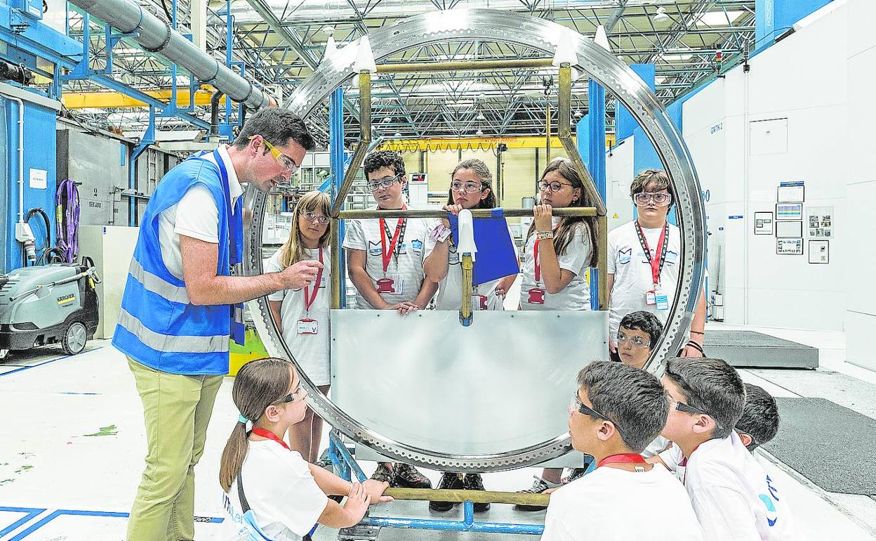 Las niñas y niños del campus atienden a las explicaciones de un empleado de ITP. 