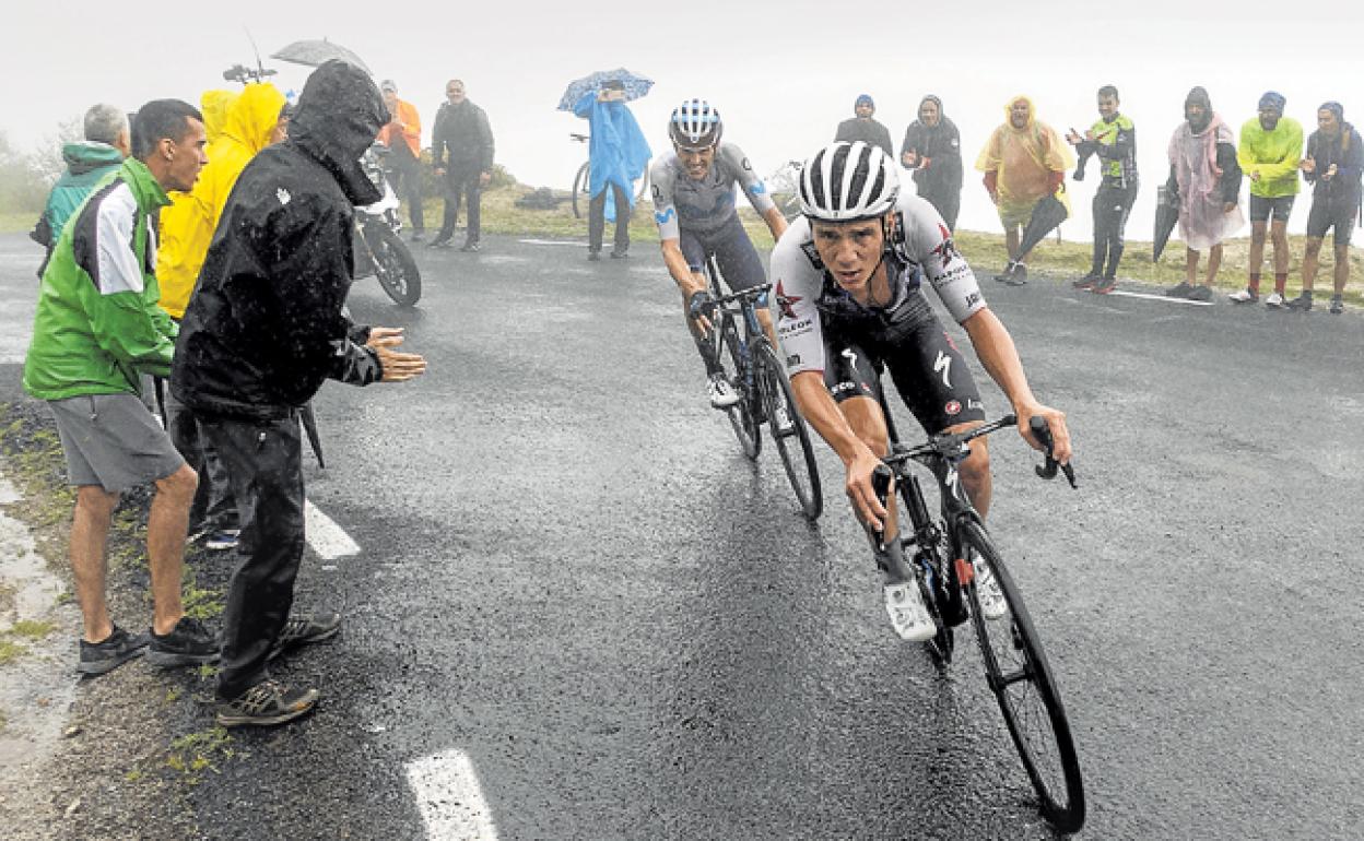 Remco Evenepoel y Enric Mas, ya solos en la subida al Pico Jano, entre la niebla y bajo la lluvia. 