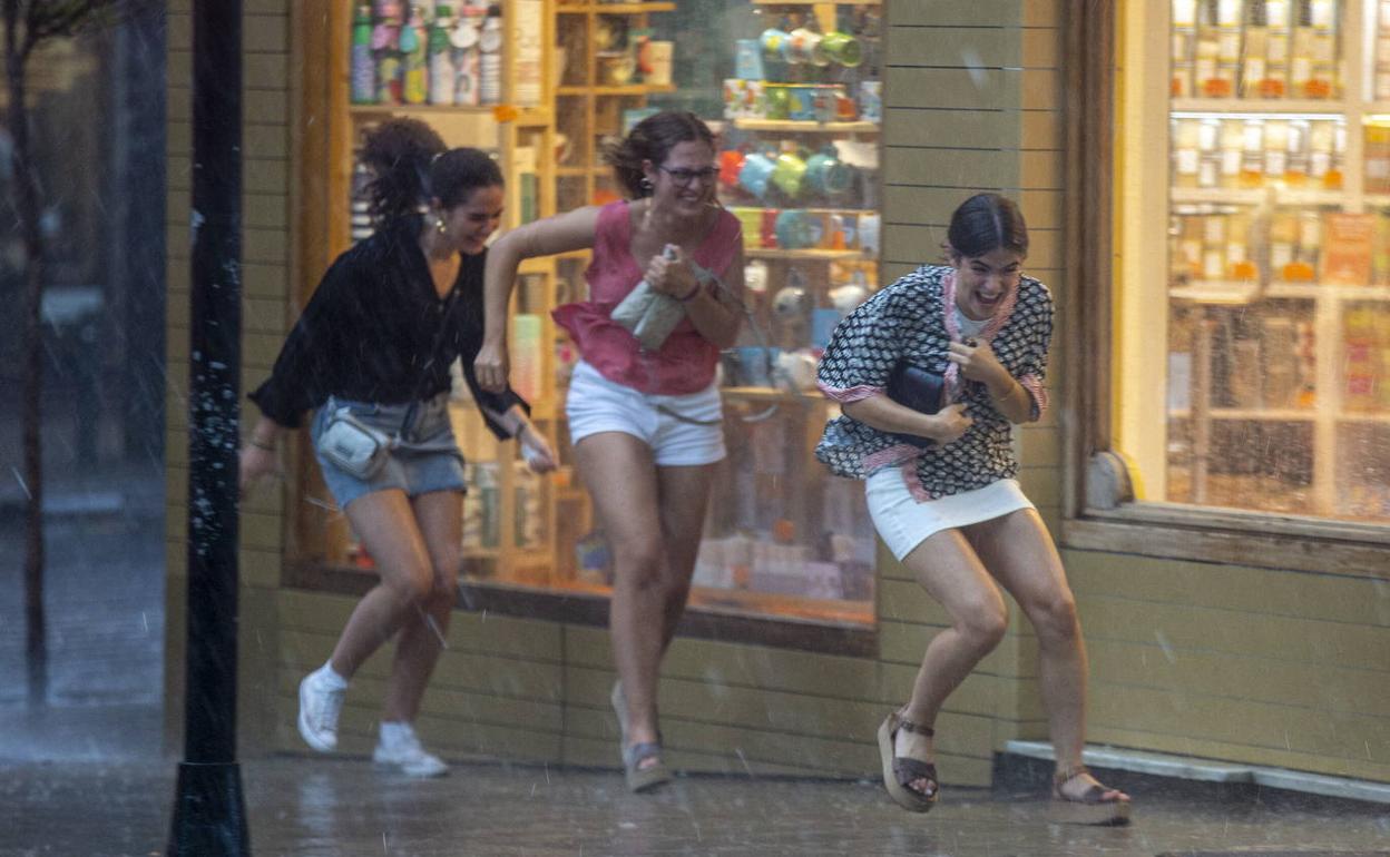 Varias mujeres sorprendidas por una tormenta en plena calle. 
