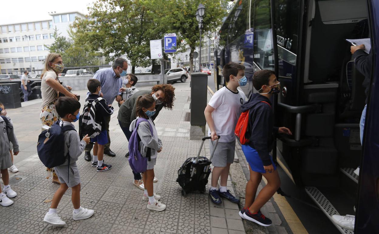 Varios niños se suben al autobús para ir al colegio