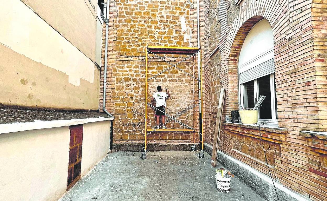 Uno de los operarios subsana las deficiencias en una de las fachadas del colegio. 