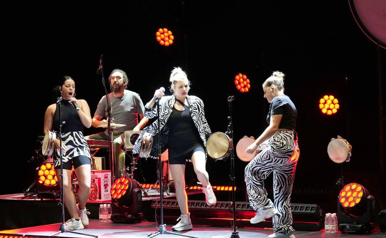 Con panderetas y playeras blancas.