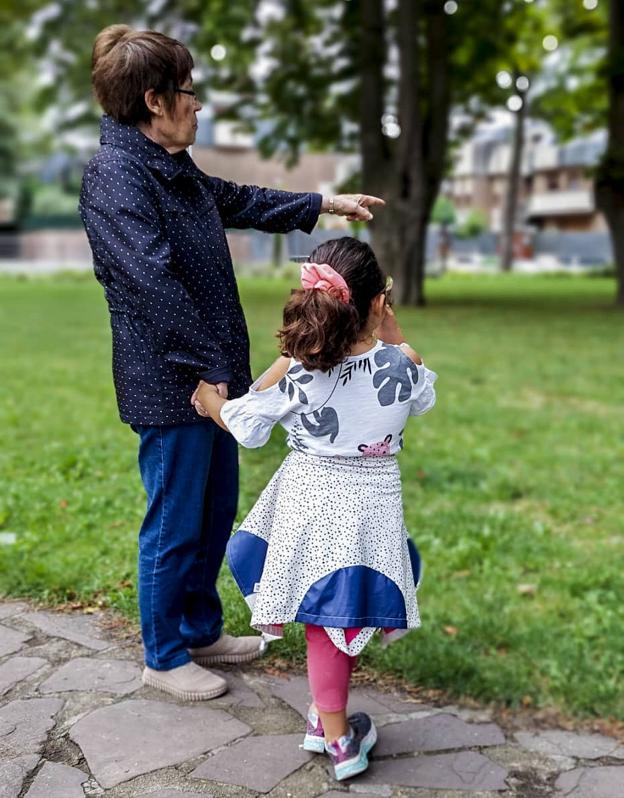 'Kuki' y su nieta pasean de la mano por un parque.