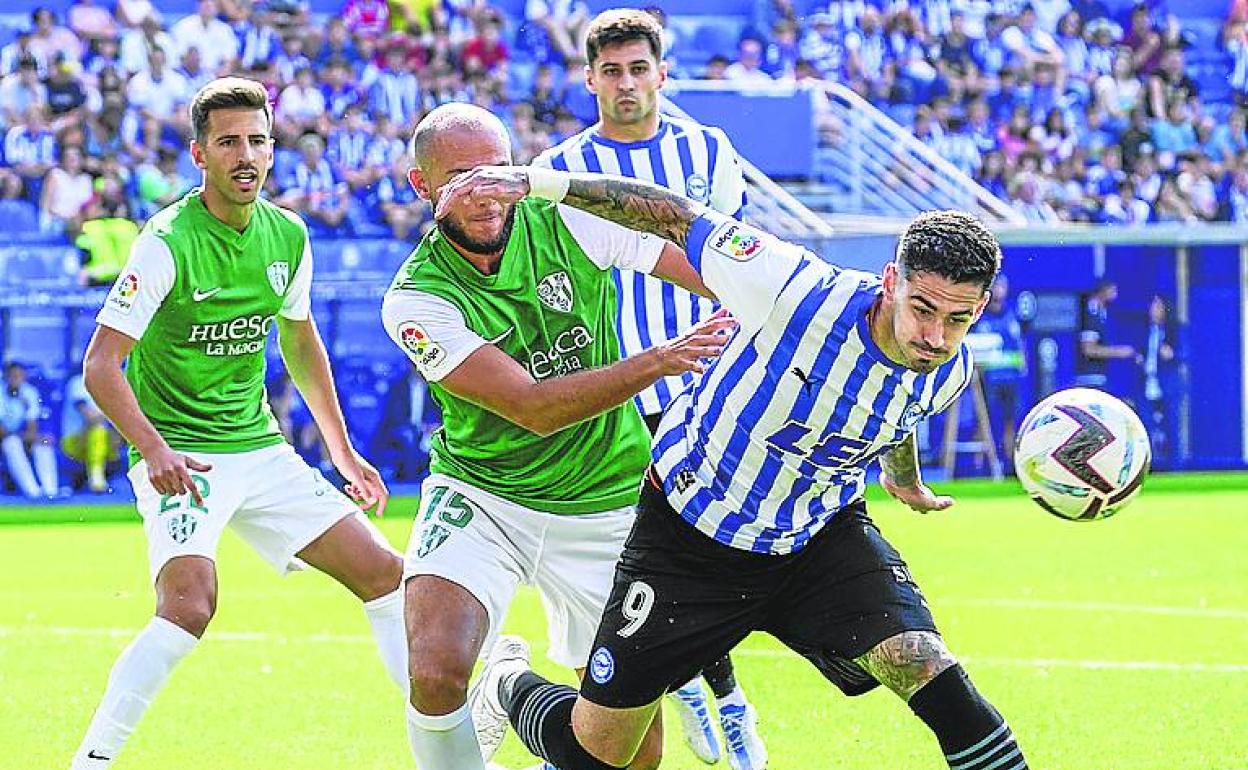 Miguel, acosado por un defensa oscense. 