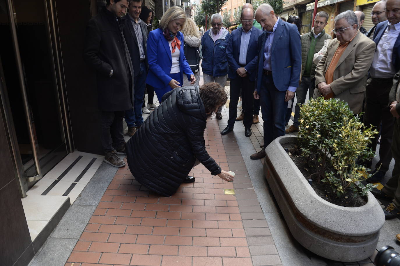 Esther Calvo, sobrina de Nicolás Martín, coloca una vela junto a la placa de su tío. 