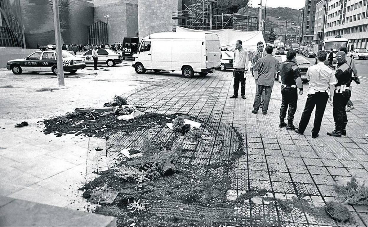 Varios ertzainas, poco después del atentado, junto a la tierra de la macetera que escondía las granadas. 