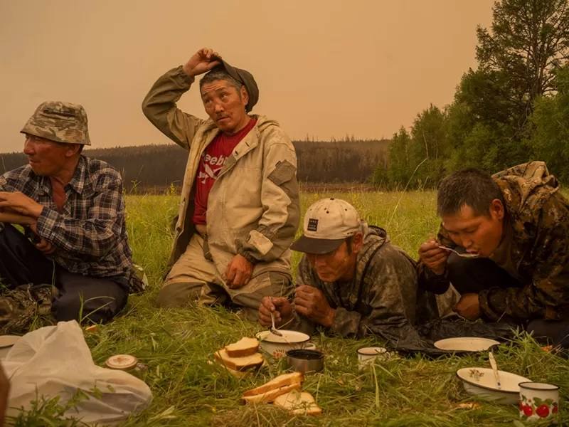 Mientras la tierra congelada arde. Voluntarios descansan para alimentarse en Magaras, Central Sakha, Siberia, Rusia.