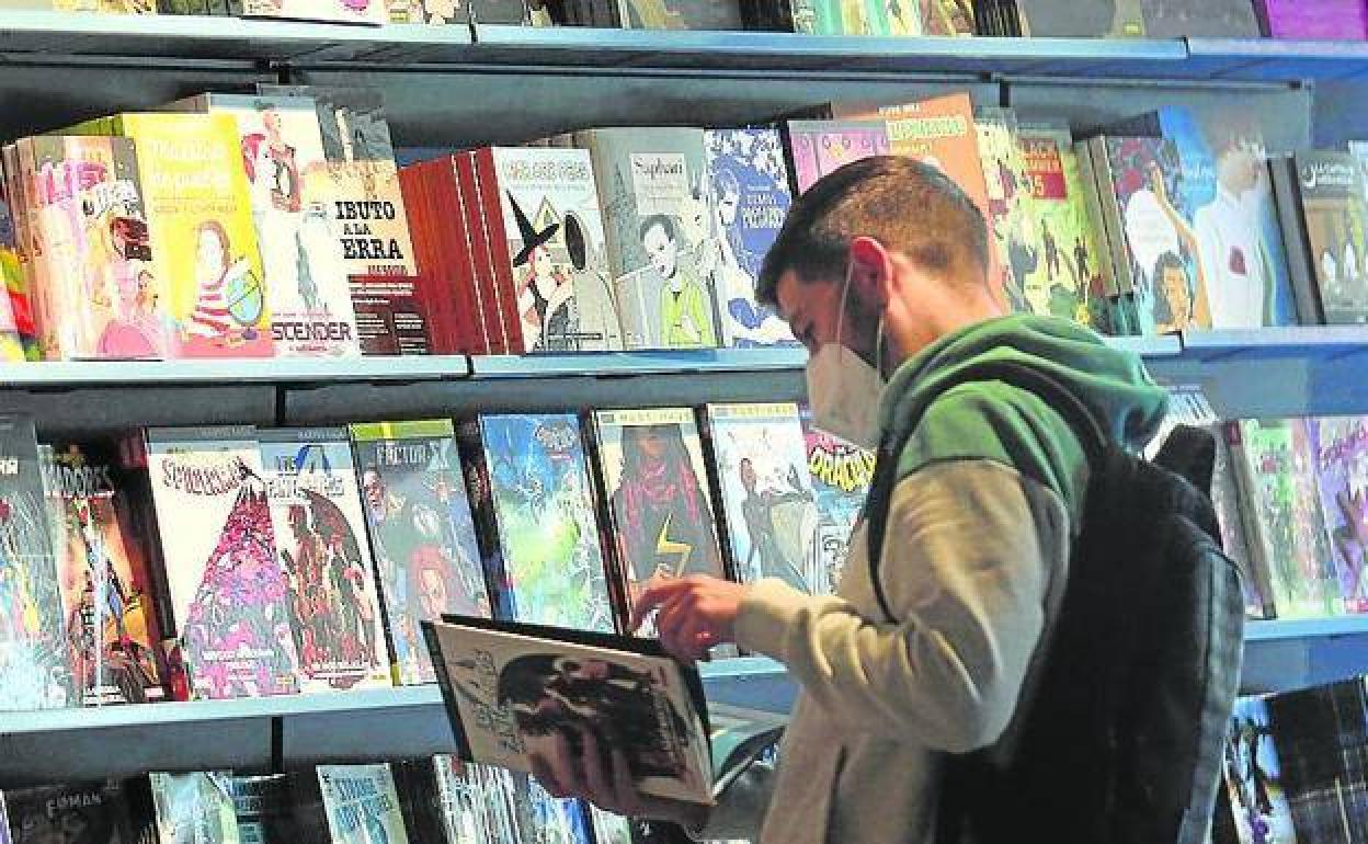Un joven ojea un cómic. 