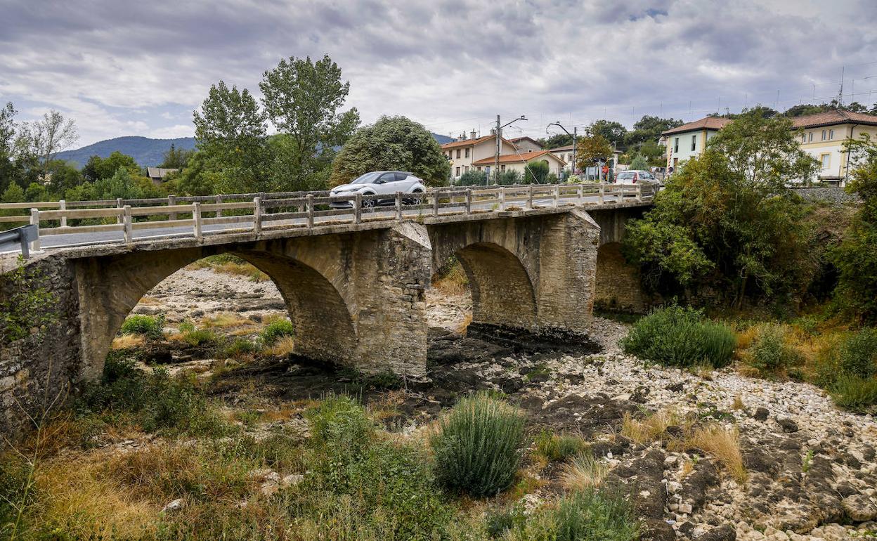 El puente de Pobes enmarca un río Baias completamente seco. 