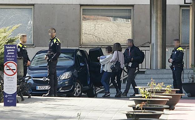 Policías locales escoltan a técnicos forales a la salida de Txagorritxu con un bebé. 