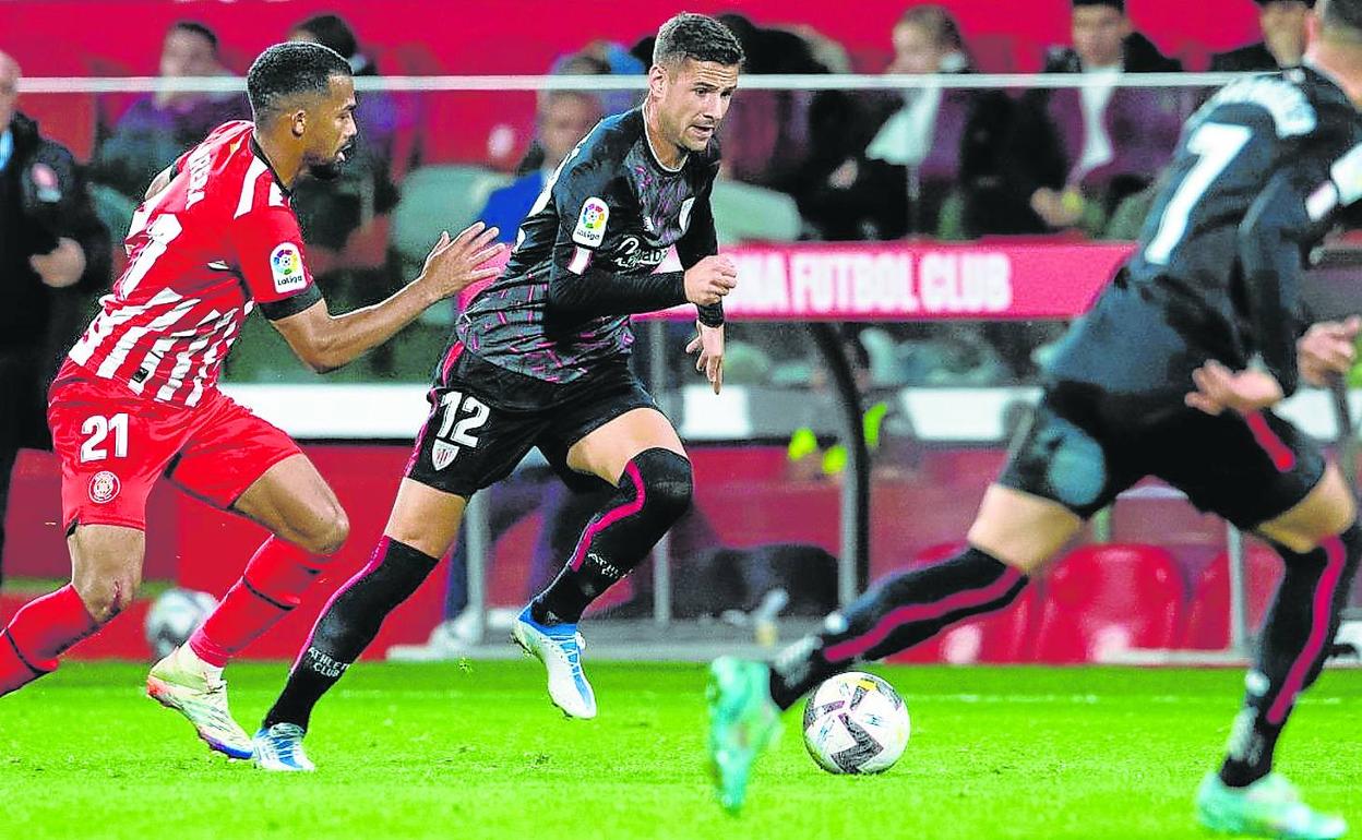 Guruzeta trata de dejar atrás a un jugador del Girona con Berenguer atento a la acción. 