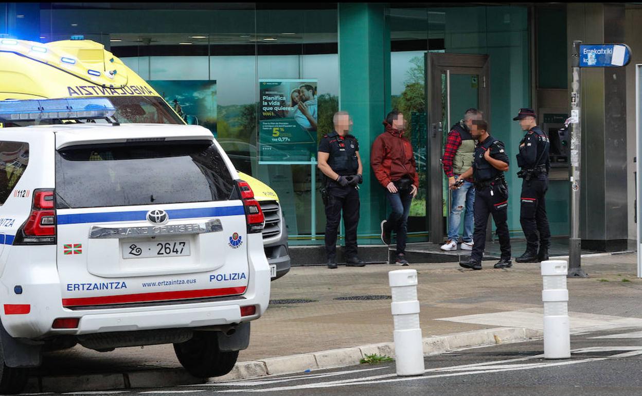 Efectivos de la Ertzaintza custodian la sucursal donde se produjo el incidente. 