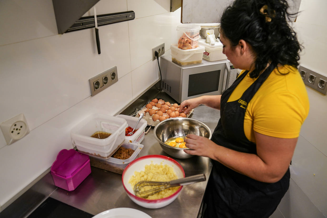 Ainara, en la cocina del bar, con los ingredientes dispuestos.