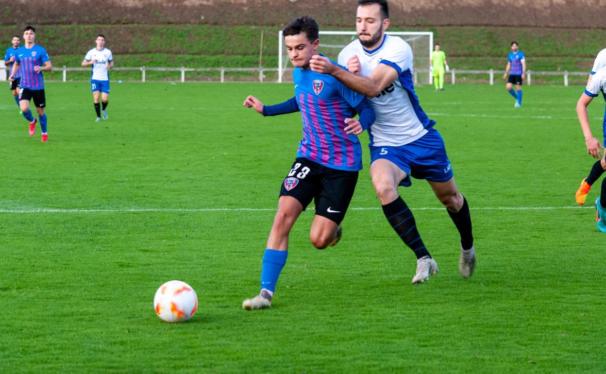 Álvaro Díez busca al área rival mientras protege el balón con el cuerpo ante la presión de Iván Castillo. 