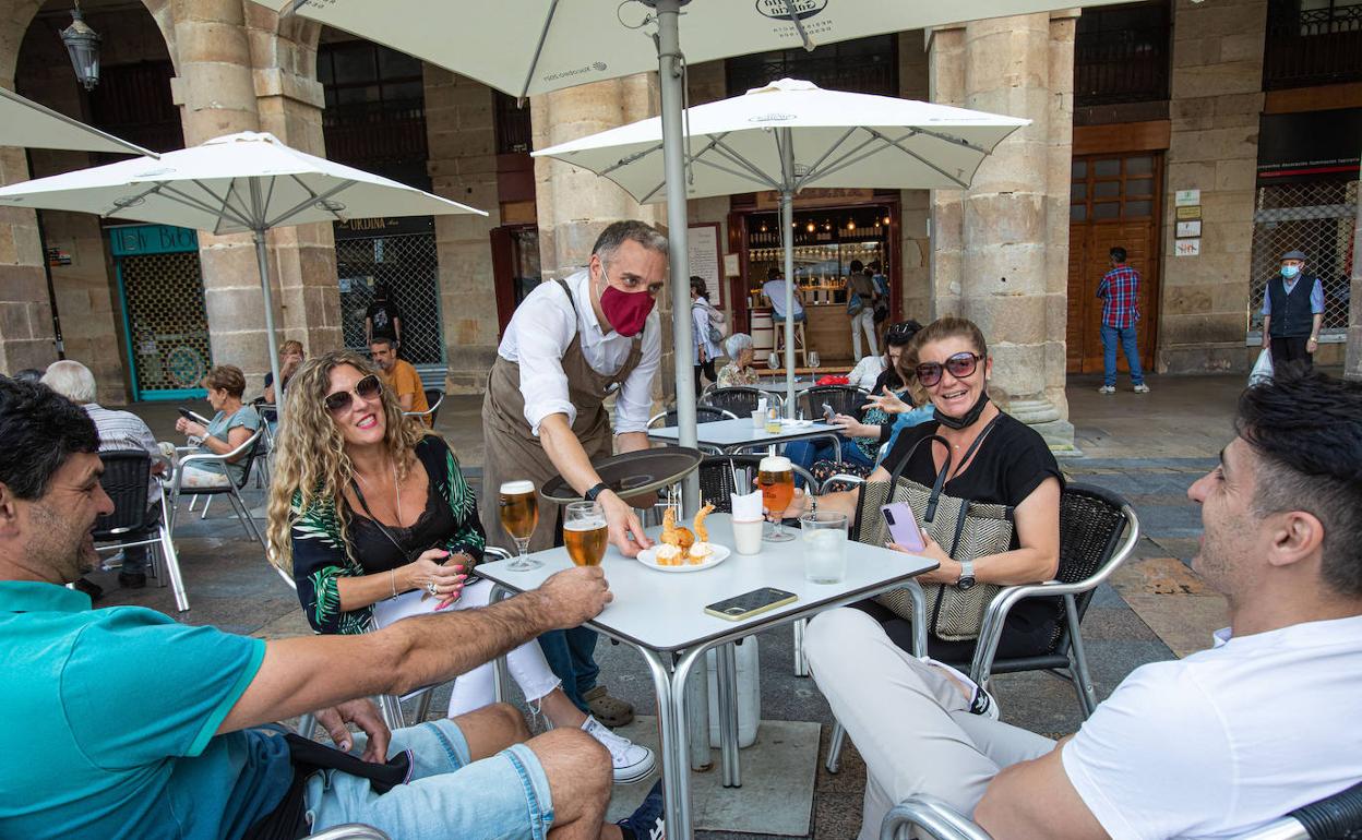Un grupo de amigos toma el aperitivo en la Plaza Nueva de Bilbao.