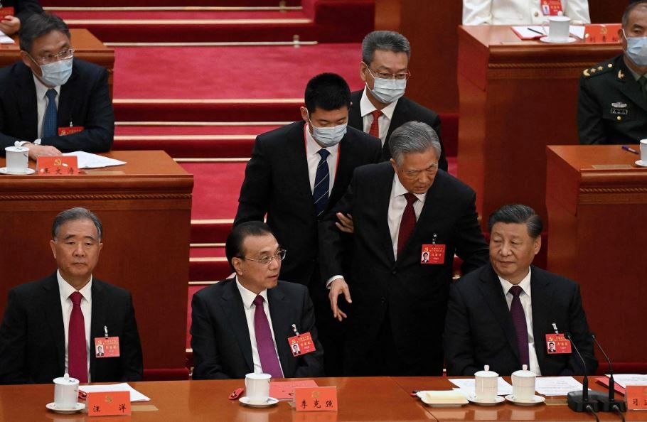 El presidente de China, Xi Jinping, se sienta junto al primer ministro Li Keqiang mientras el expresidente Hu Jintao es asistido para salir de la ceremonia de clausura del 20º Congreso del Partido Comunista de China en el Gran Salón del Pueblo en Beijing el 22 de octubre. 