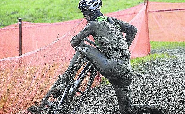 Un ciclocrossista embadurnado pierde el equilibrio.