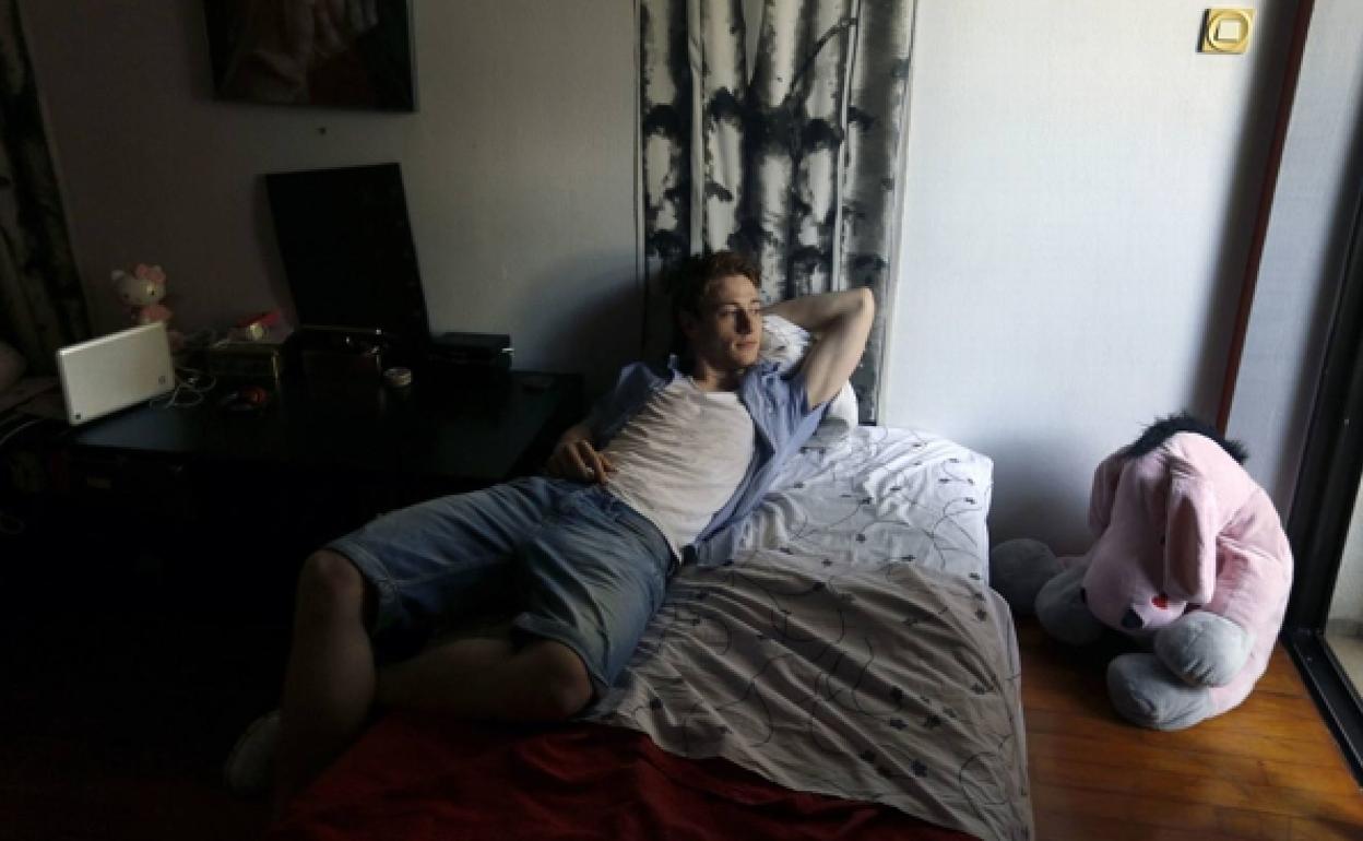 Un joven, en su habitación en casa de sus padres.