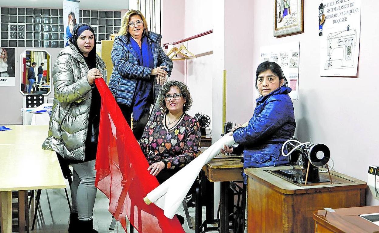 Aprendizaje. Yousra, Mayte, Begoña y Soledad, con unas telas en el aula de costura del centro Hargindegi.