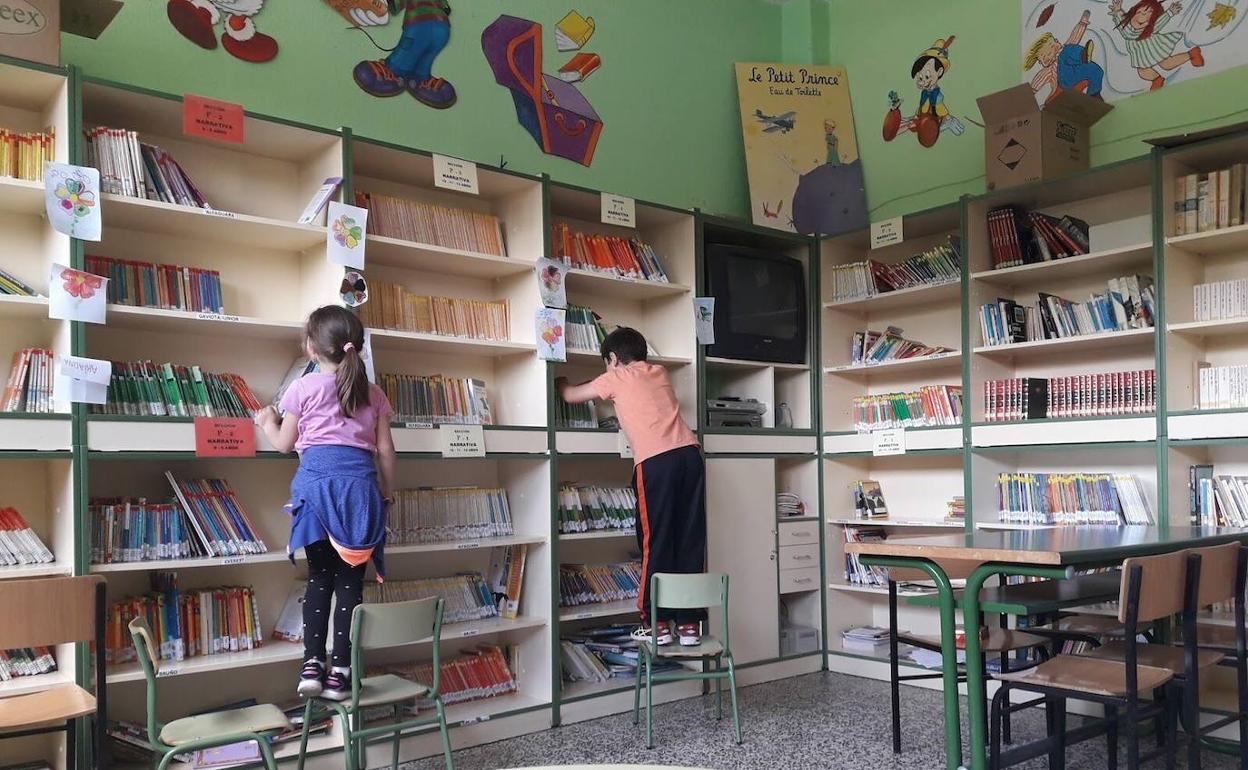 Alumnos de El Príncipe buscan libros en las estanterías de la biblioteca. 