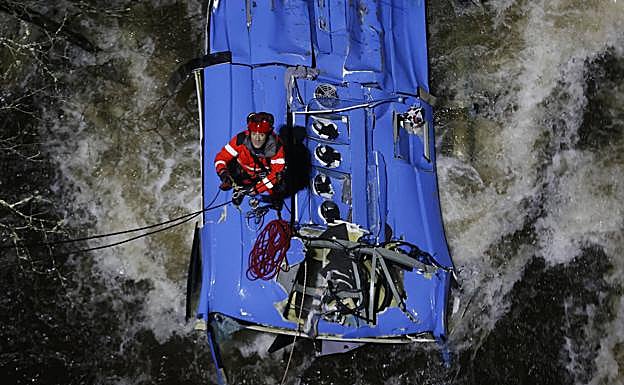 Los bomberos trabajan en el rescate de víctimas del autobús que se precipitó al río Lérez. 