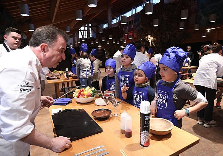 Martín Berasategui se dispone a hacer una brocheta ante los expectantes chavales congregados por la Fundación Pequeño Deseo.