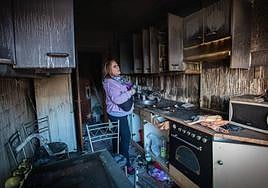 Una vecina observa los daños provocados en un piso incendiado en Santutxu, por segunda vez en dos meses, el pasado 3 de enero