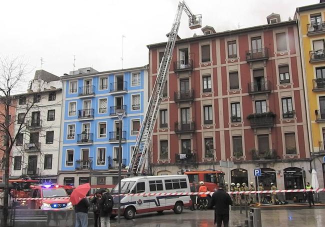 Los bomberos supervisan desde lo alto de la escala el tejado.